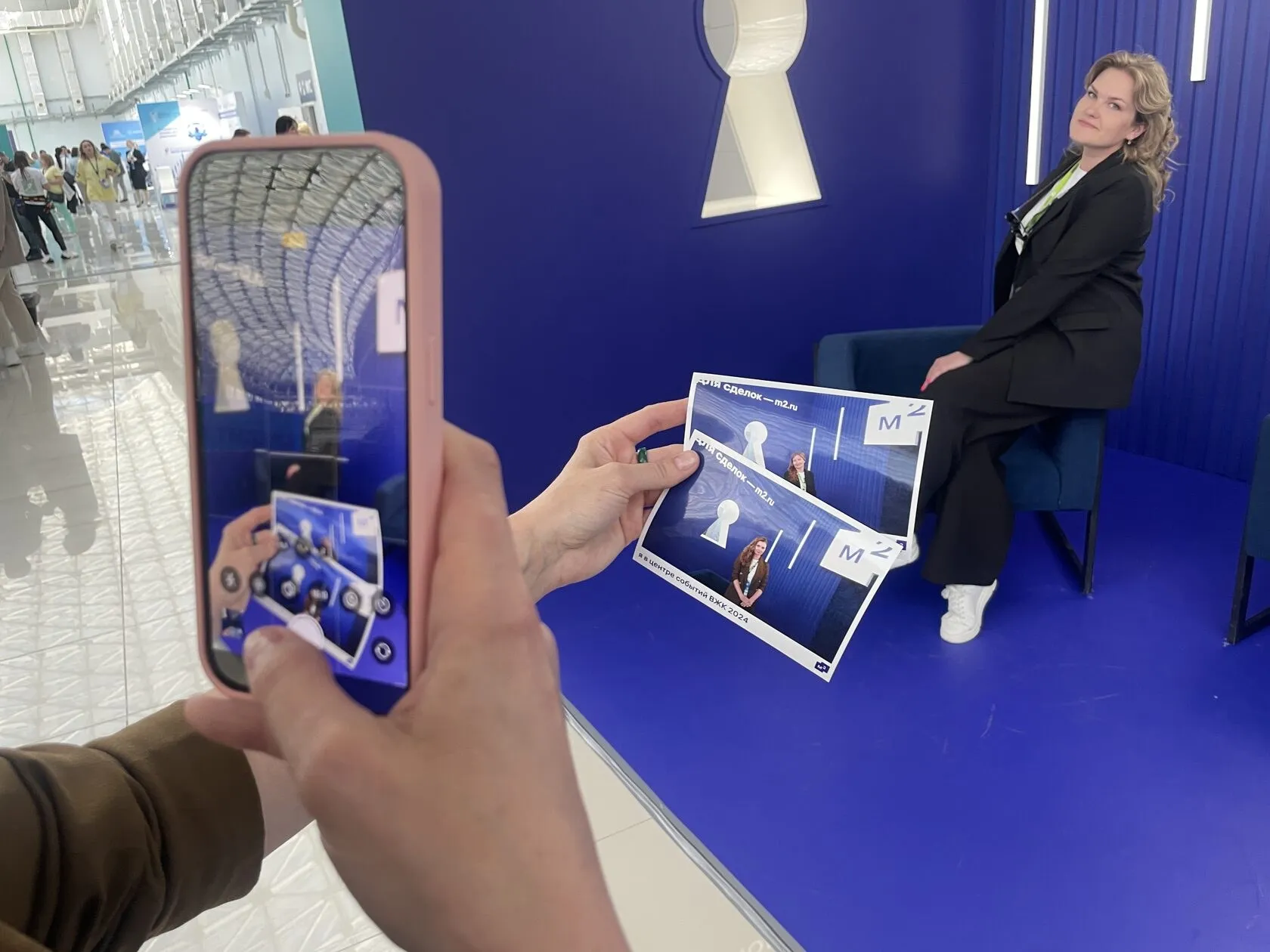 Гостья фотографирует распечатку на стенде